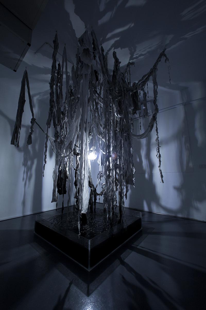 〈滲透〉，2019，純棉布、半棉布、尼龍仿棉布、墨汁、水、透明壓克力箱、、燈球、LED燈泡，自轉馬達、沉水抽水馬達，依場地而定的封面圖